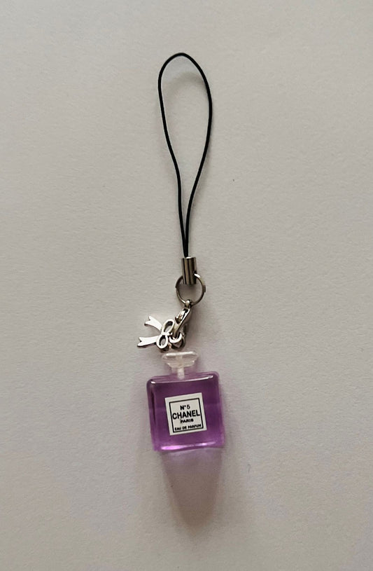 Purple Chanel No.5 perfume bottle phone charm with silver bow on a black strap