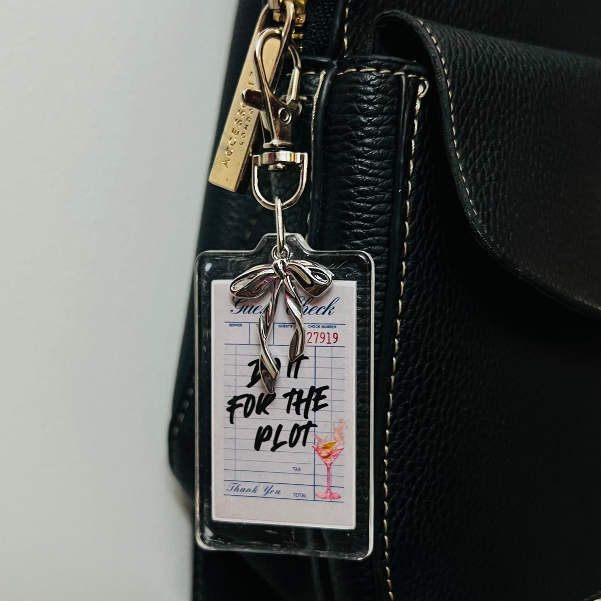 Do It For The Plot acrylic receipt bag charm with a silver bow