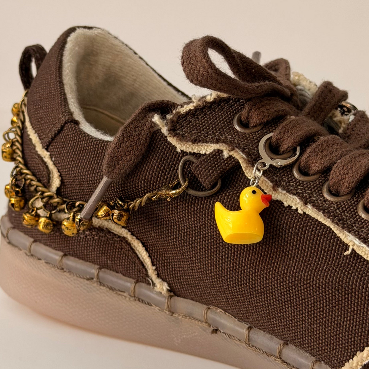Ducky Shoe Charm, yellow rubber duck charm on the laces of a brown canvas sneaker