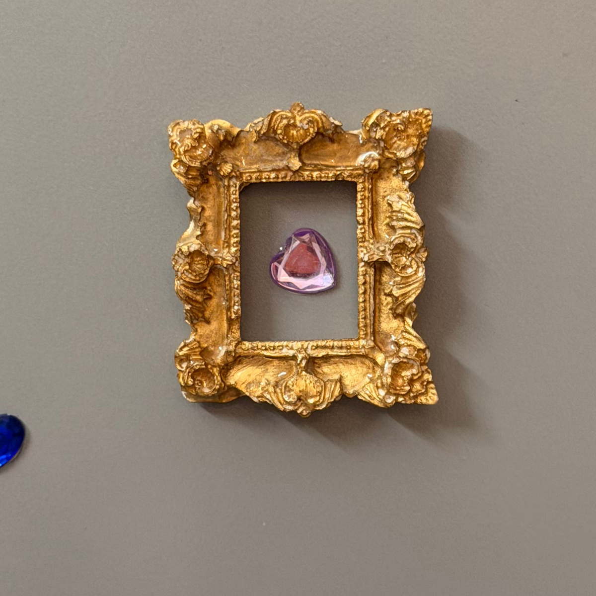 Photo Holders and Frames, a gold and a silver concrete miniature photo frame on a fridge door