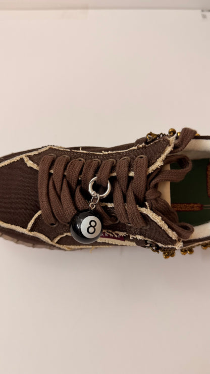 8Ball Shoe Charm, glossy black 8 ball charm on the laces of a brown canvas sneaker