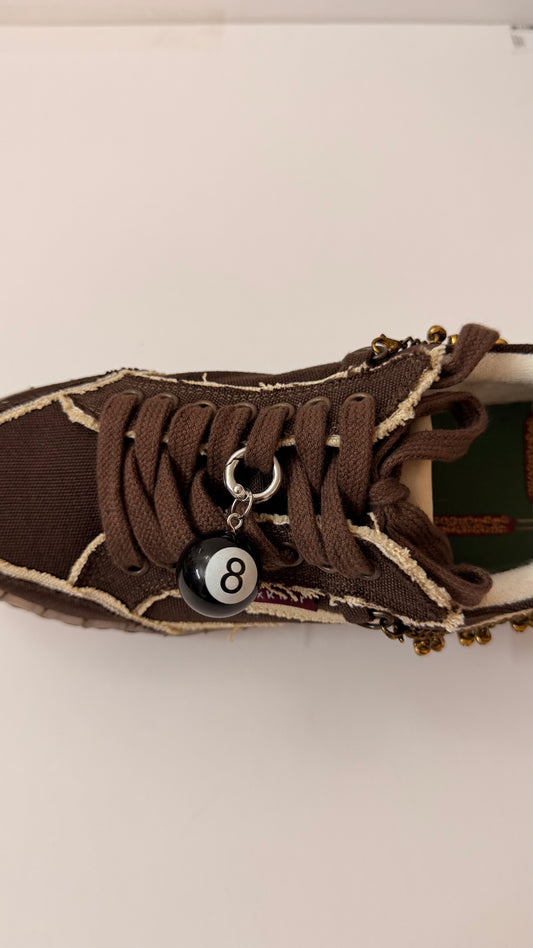 8Ball Shoe Charm, glossy black 8 ball charm on the laces of a brown canvas sneaker
