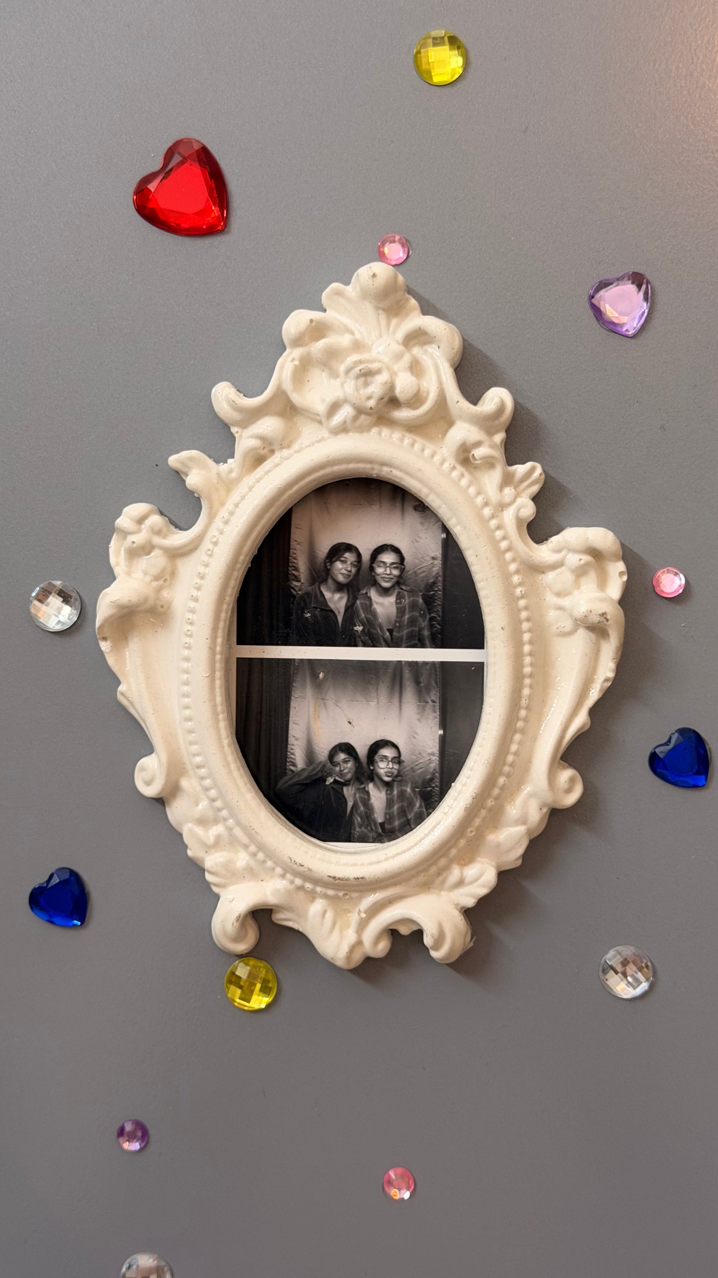 Antique Royal Magnetic Frame, white concrete baroque frame with a beaded rim, holding a photo booth strip