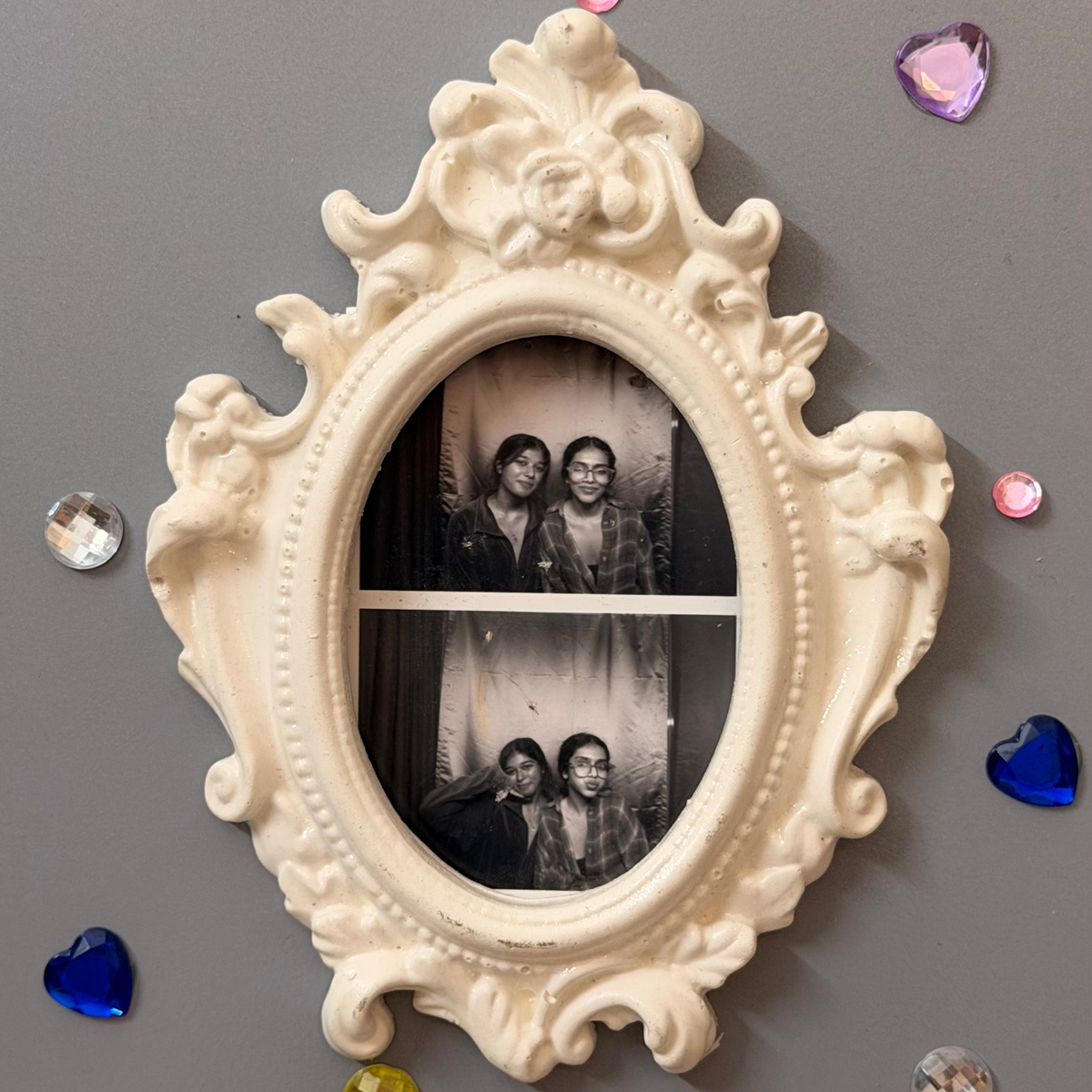 Antique Royal Magnetic Frame, white concrete baroque frame with a beaded rim, holding a photo booth strip