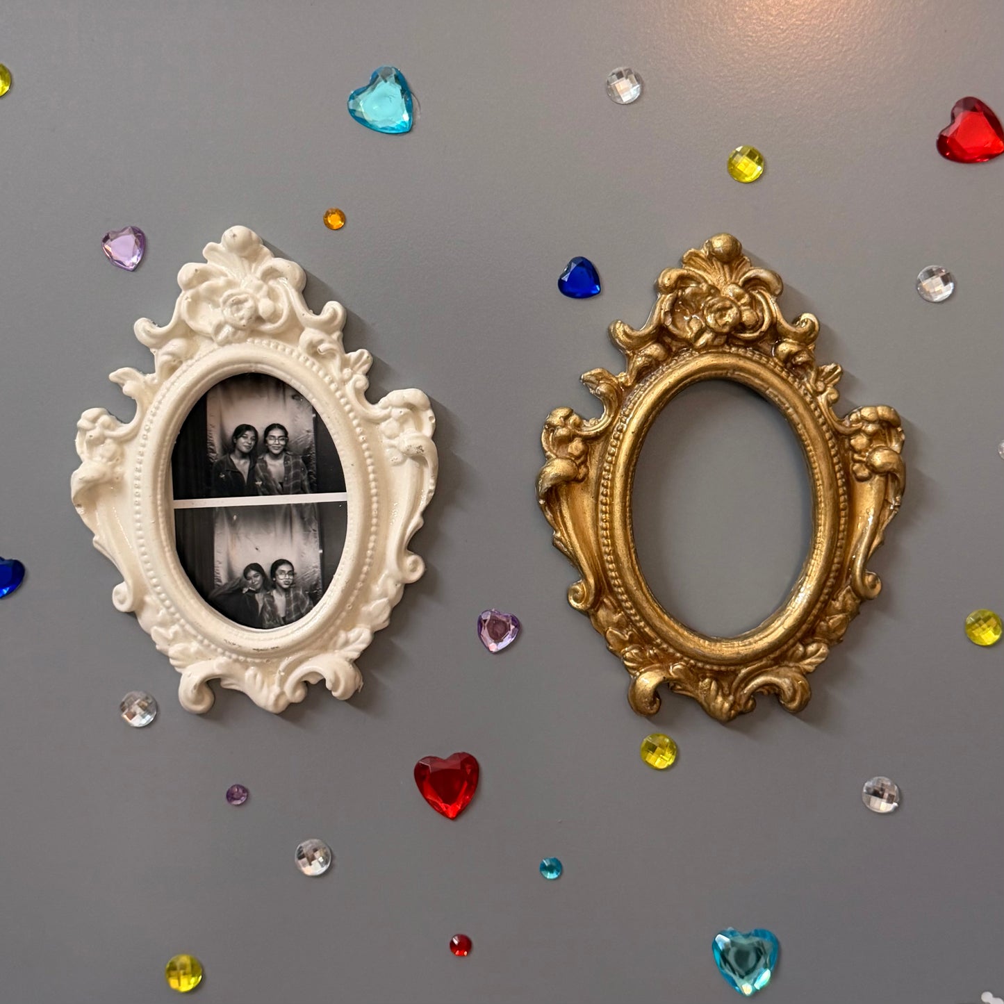 Antique Royal Magnetic Frame, white and gold concrete baroque frames side by side, the white one holding a photo booth strip