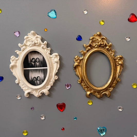 Antique Royal Magnetic Frame, white and gold concrete baroque frames side by side, the white one holding a photo booth strip
