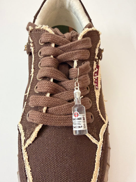 Bacardi Shoe Charm, mini Bacardi rum bottle charm on the laces of a brown canvas sneaker