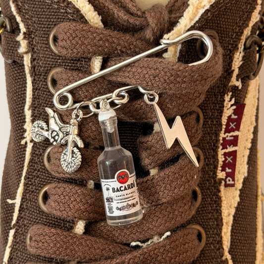Bad Influence, silver brooch pin with dirt bike, Bacardi bottle and lightning bolt charms
