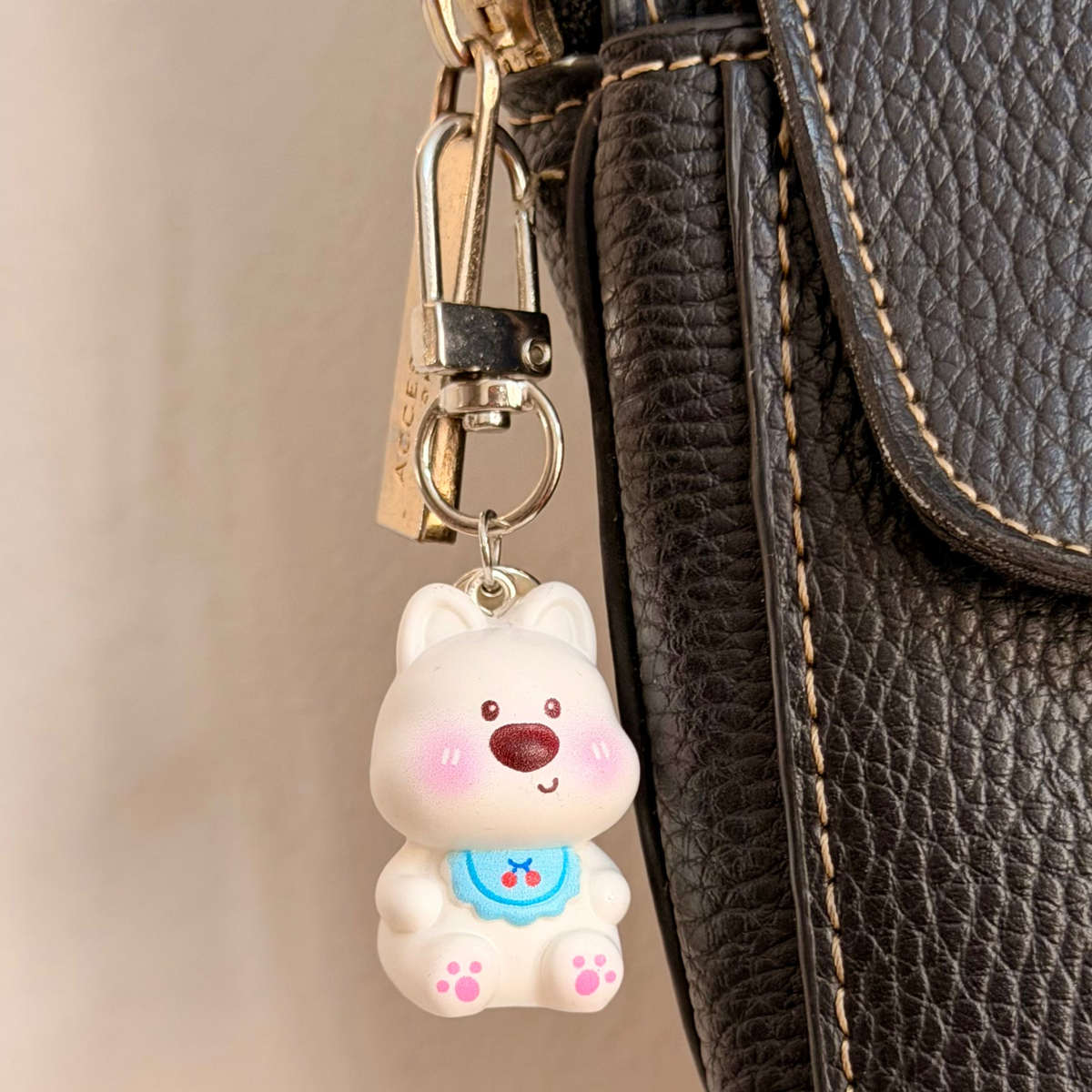 Bibbidi Bobbidi Boo, a white puppy in a blue bib patterned with red cherries.
