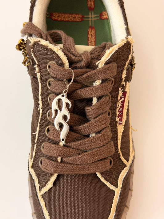 Blaze Shoe Charm, silver racing flame charm on the laces of a brown canvas sneaker
