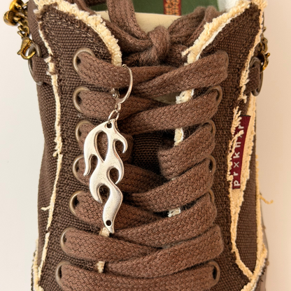 Blaze Shoe Charm, silver racing flame charm on the laces of a brown canvas sneaker