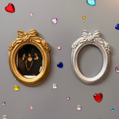 Bow and Blooms Magnetic Frame, three concrete oval frames on a fridge door, gold holding a photo, silver empty and gold empty
