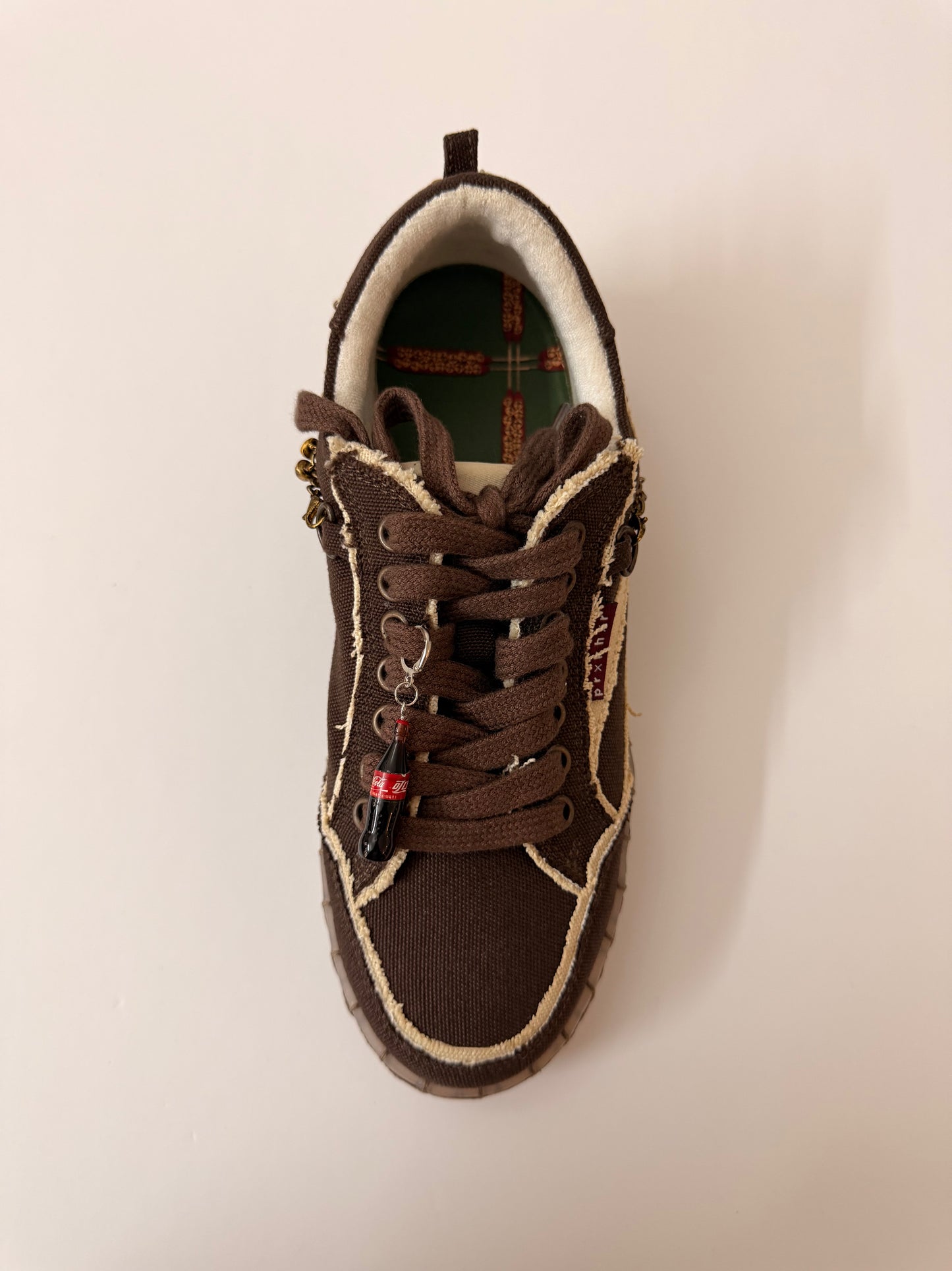 Coke Bottle Shoe Charm, mini Coca-Cola glass bottle charm on the laces of a brown canvas sneaker