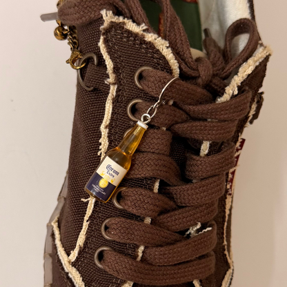 Corona Shoe Charm, mini Corona Extra beer bottle charm on the laces of a brown canvas sneaker