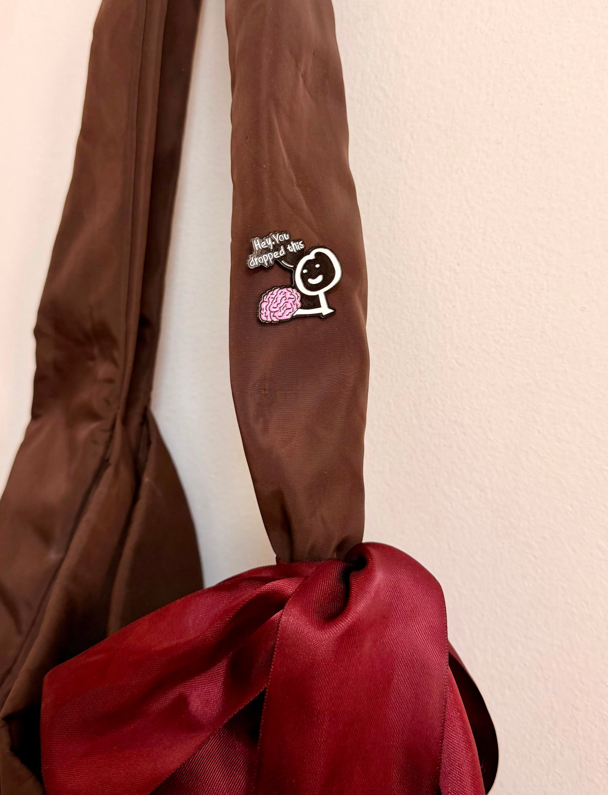 Currently Loading Enamel Pin, smiling character handing over a pink brain
