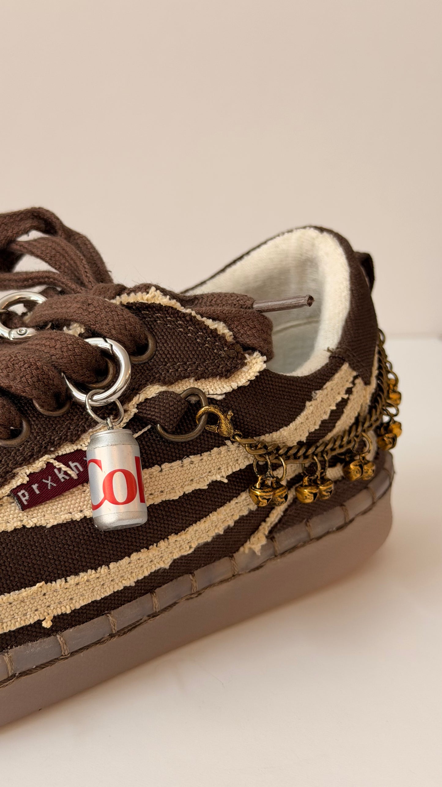 Diet Coke Shoe Charm, mini silver Diet Coke can charm on the laces of a brown canvas sneaker