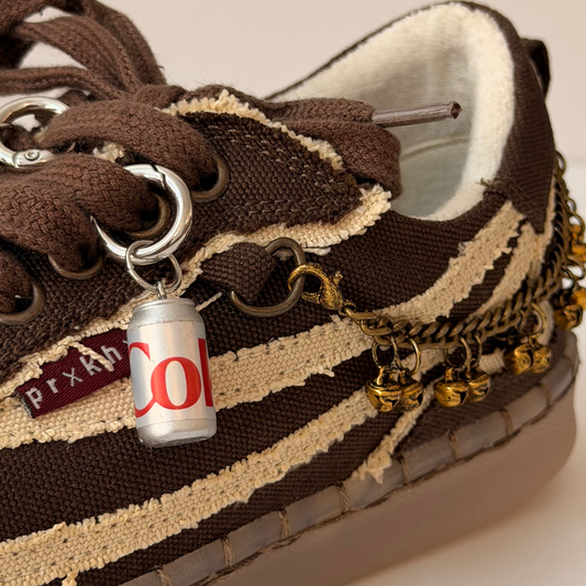 Diet Coke Shoe Charm, mini silver Diet Coke can charm on the laces of a brown canvas sneaker