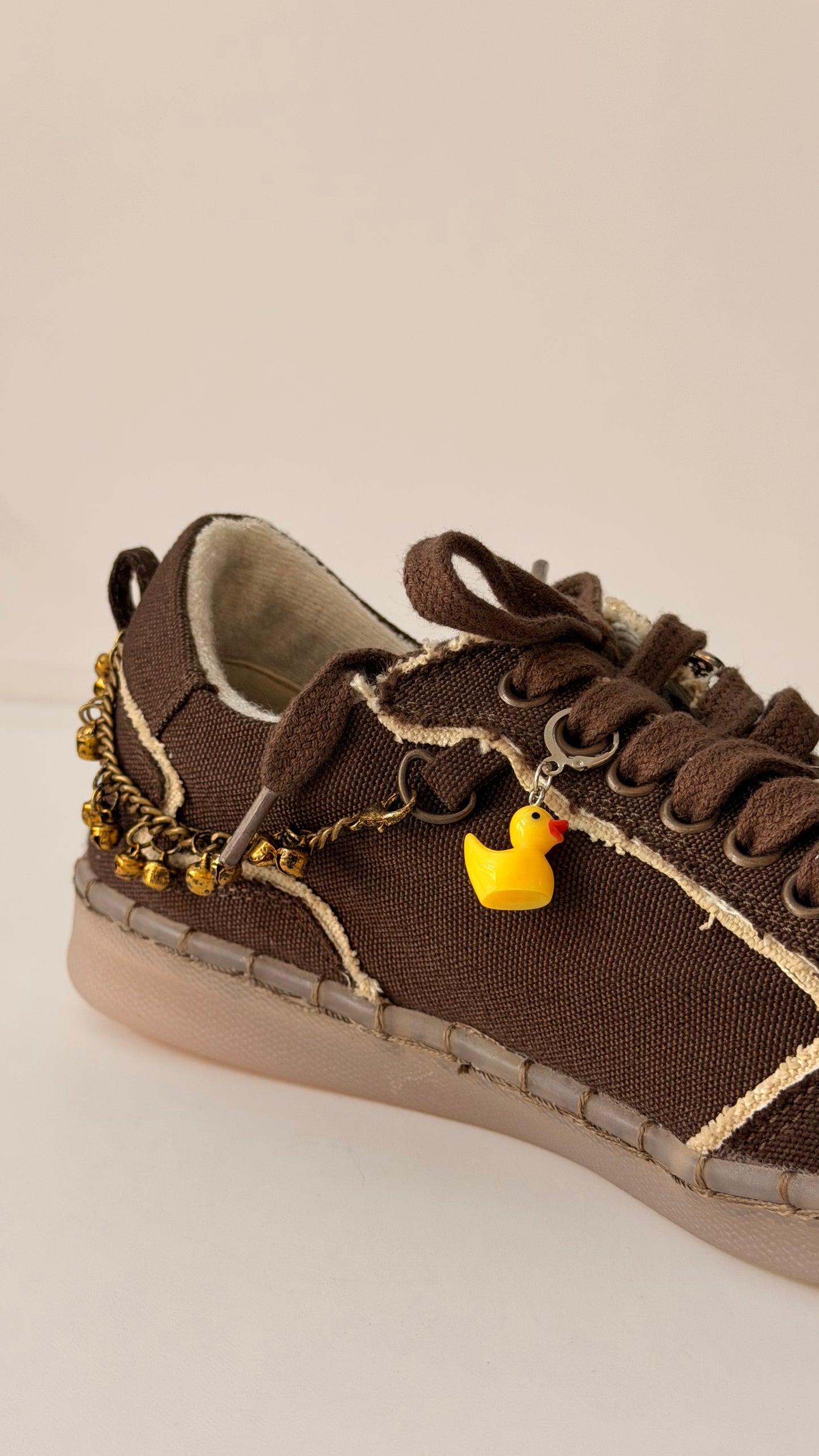 Ducky Shoe Charm, yellow rubber duck charm on the laces of a brown canvas sneaker