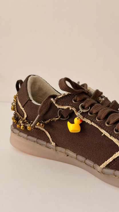 Ducky Shoe Charm, yellow rubber duck charm on the laces of a brown canvas sneaker
