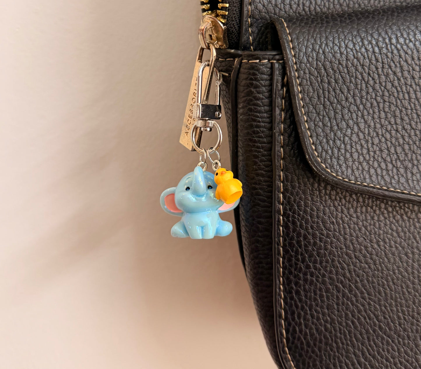 Ducky and Dumbo, a blue baby elephant with a yellow duckling on its trunk shown from another angle.
