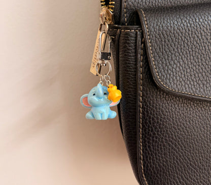 Ducky and Dumbo, a blue baby elephant with a yellow duckling on its trunk shown from another angle.
