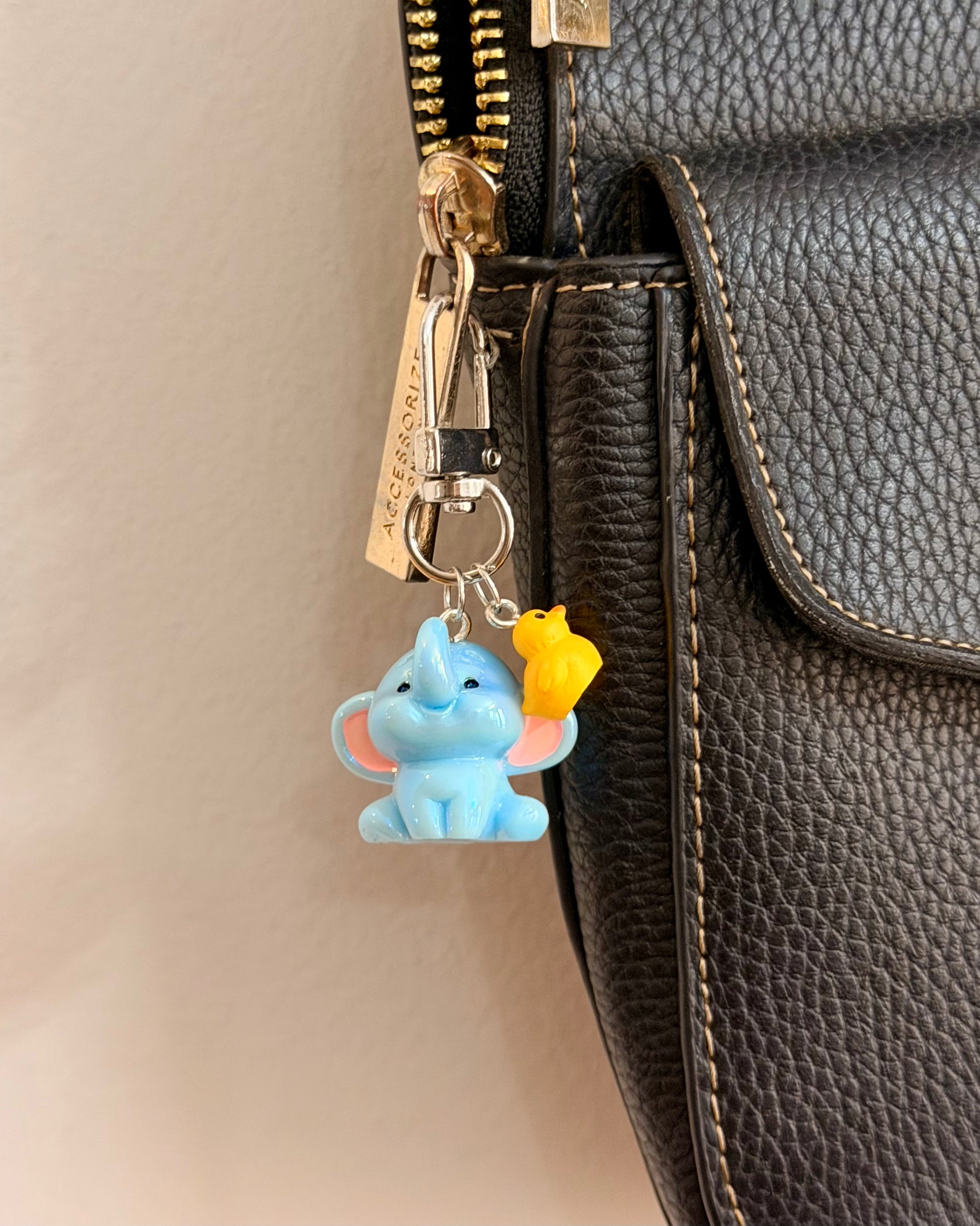Ducky and Dumbo, a blue baby elephant with a yellow duckling on its trunk shown from another angle.