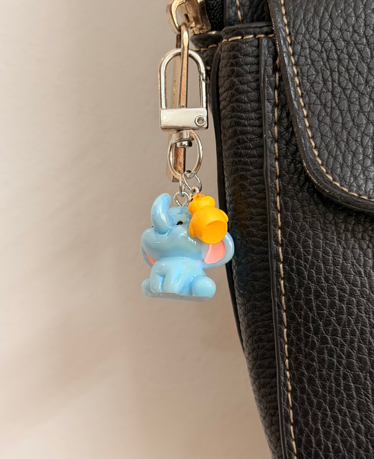 Ducky and Dumbo, a blue baby elephant with a yellow duckling on its trunk shown from another angle.