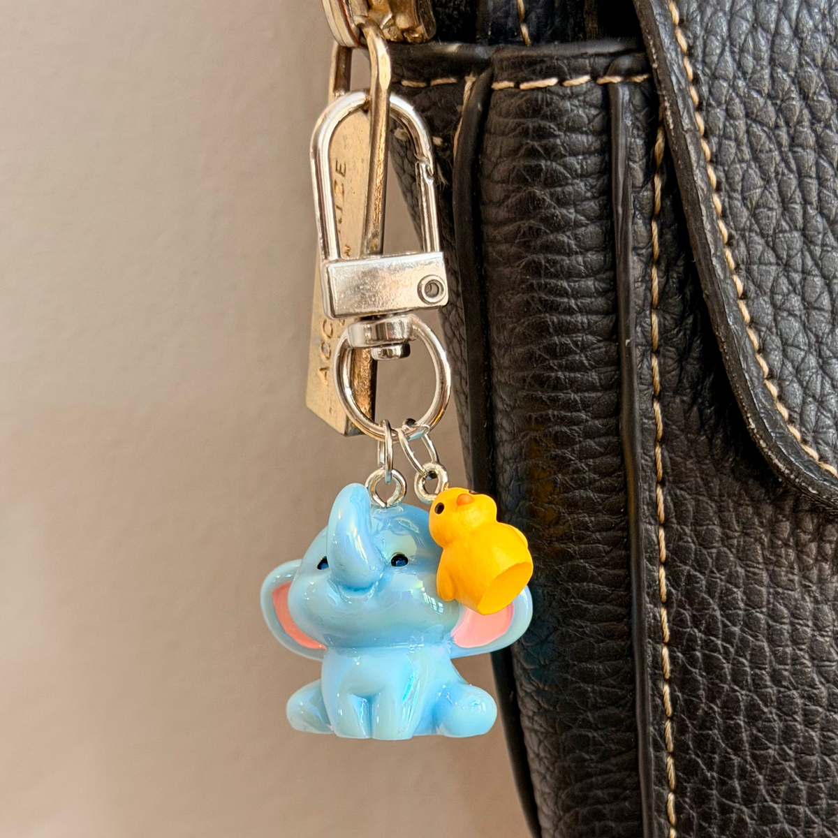 Ducky and Dumbo, a blue baby elephant with a yellow duckling on its trunk.