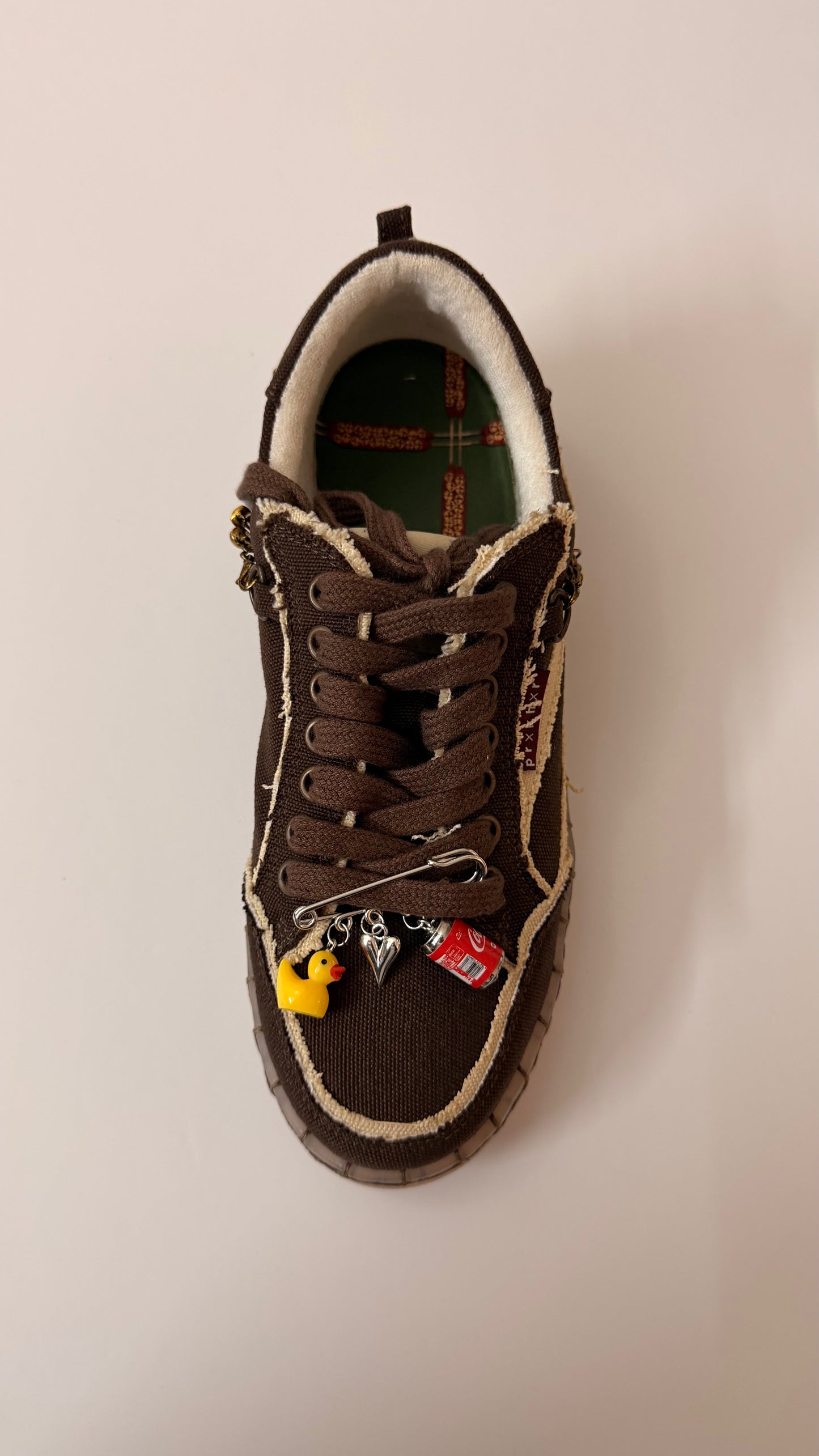 Ducky on Duty, brooch pin fastened to the laces of a brown canvas sneaker