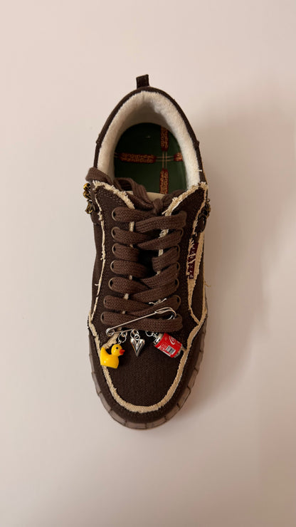Ducky on Duty, brooch pin fastened to the laces of a brown canvas sneaker