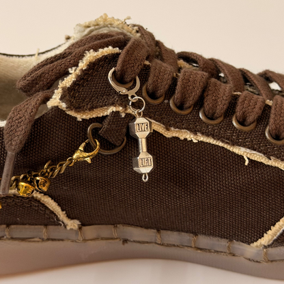 Dumbbell Shoe Charm, silver LIVE LIFT dumbbell charm on the laces of a brown canvas sneaker