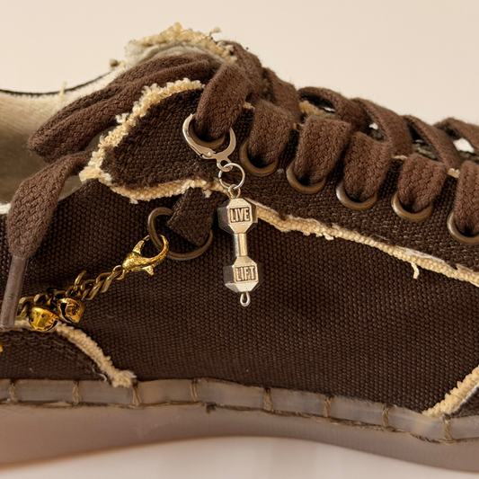 Dumbbell Shoe Charm, silver LIVE LIFT dumbbell charm on the laces of a brown canvas sneaker