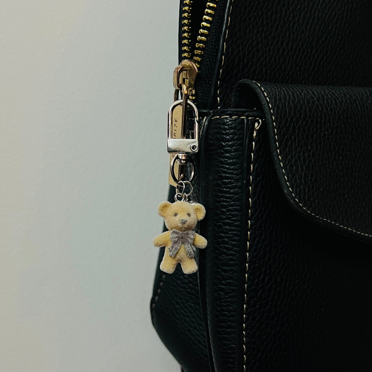 Furry brown teddy bear bag charm with a bow and a heart charm