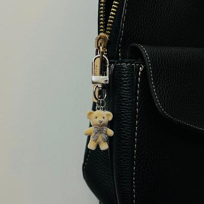 Furry brown teddy bear bag charm with a bow and a heart charm
