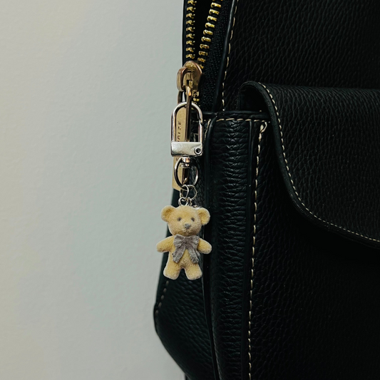 Furry brown teddy bear bag charm with a bow and a heart charm