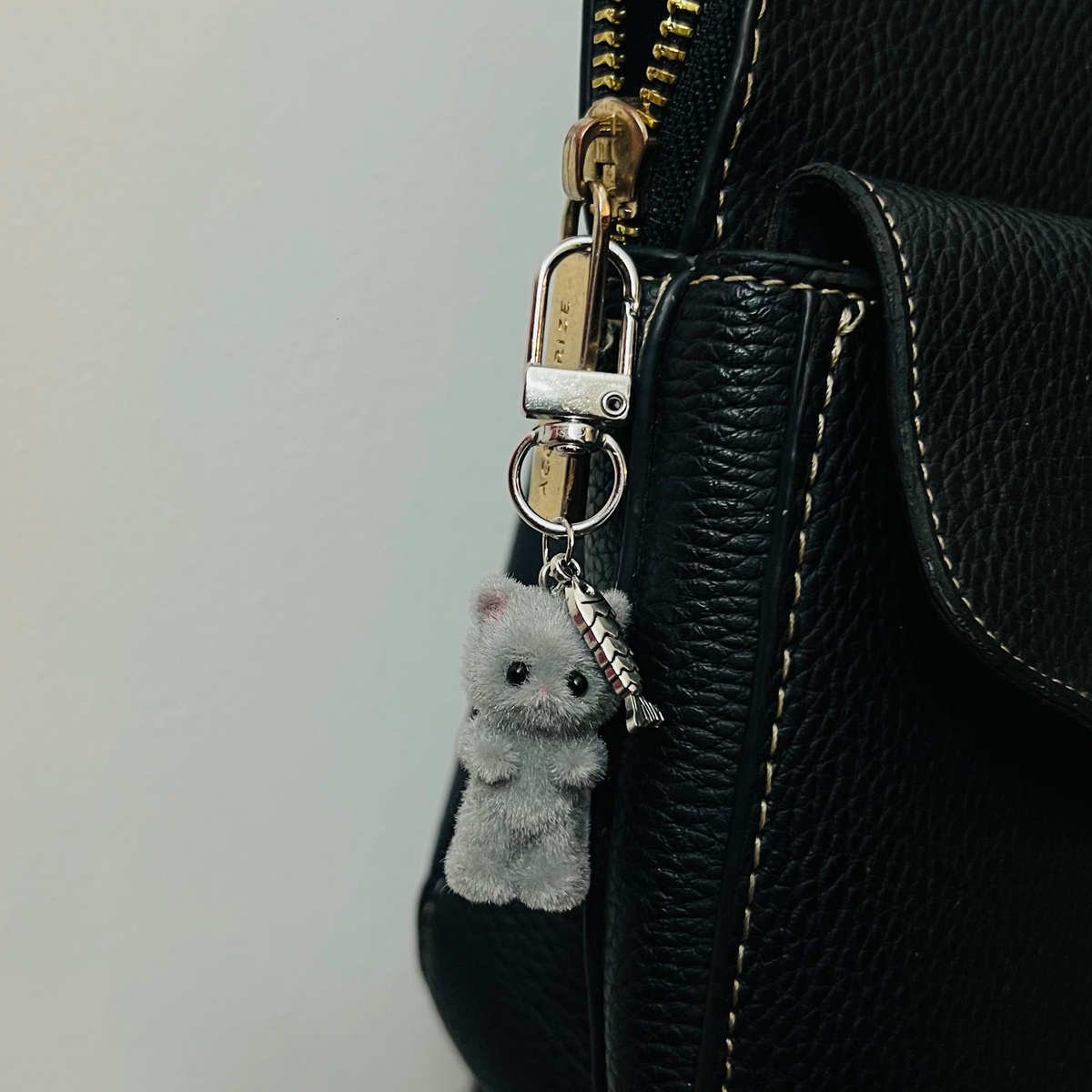 Furry grey cat bag charm with a silver fish charm