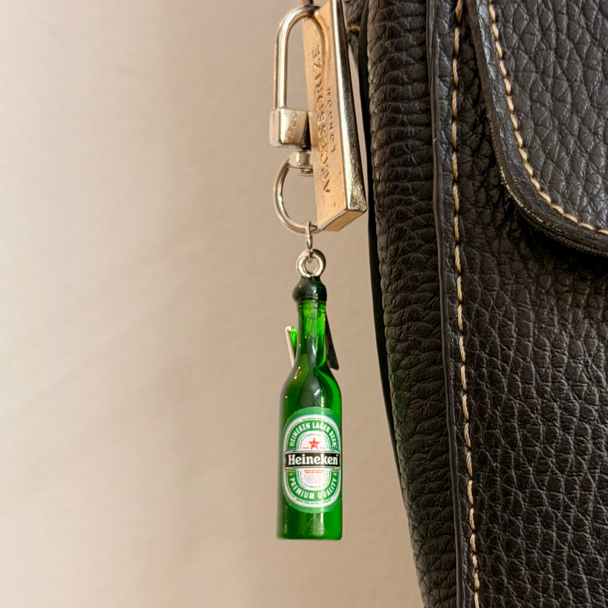 Heineken with Thunderbolt, a miniature green beer bottle with a silver thunderbolt charm.