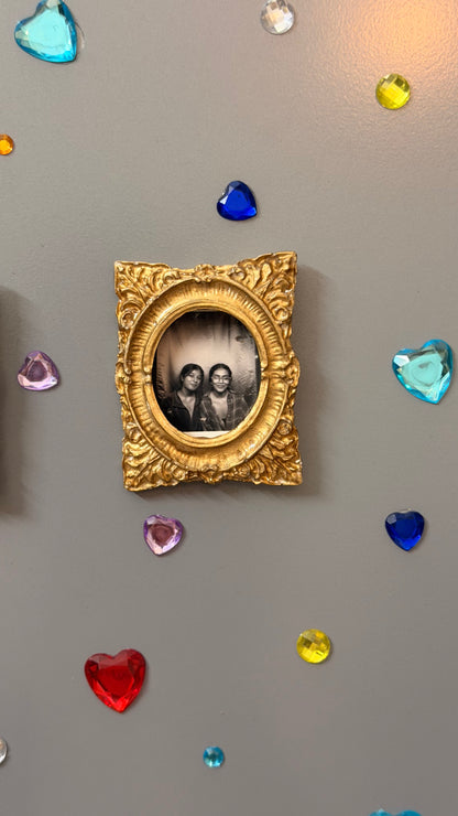 Hold This Moment Magnetic Frame, gold concrete frame with an oval opening holding a black and white photo