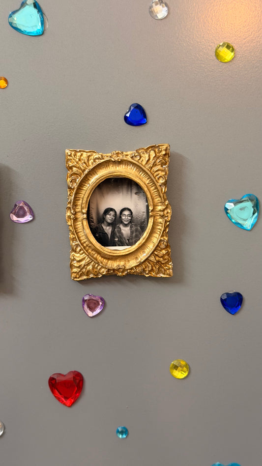 Hold This Moment Magnetic Frame, gold concrete frame with an oval opening holding a black and white photo