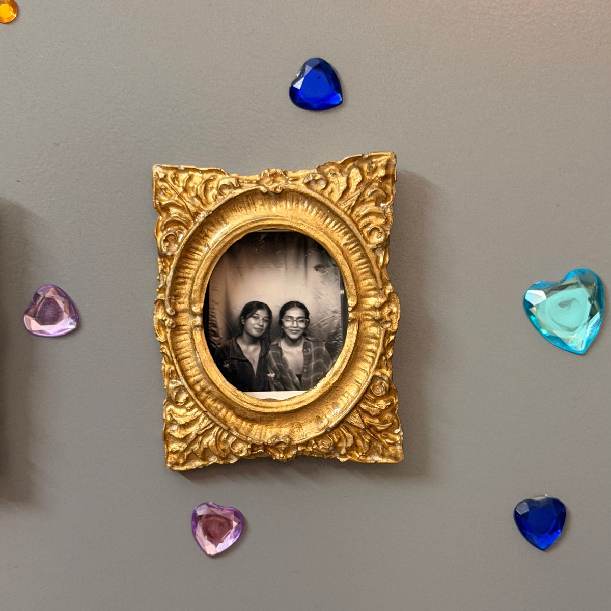 Hold This Moment Magnetic Frame, gold concrete frame with an oval opening holding a black and white photo