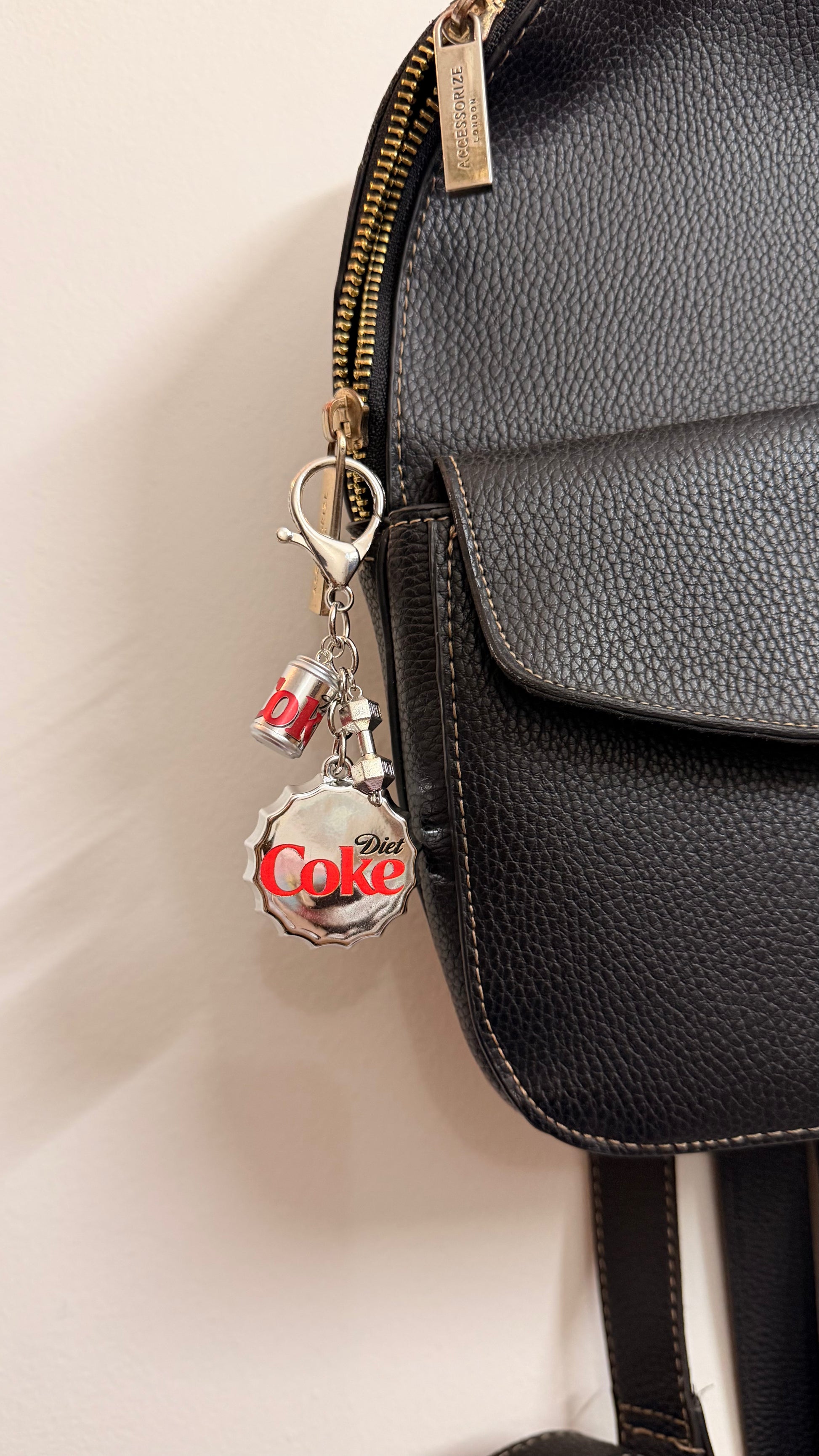 Pop the Cap, an oversized silver Diet Coke bottle cap with a miniature can and a silver dumbbell charm shown from another angle.