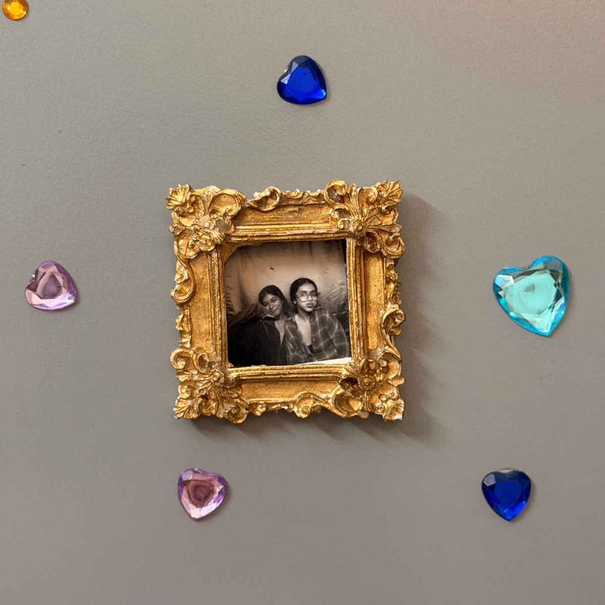 The Nostalgic Magnetic Frame, gold concrete square frame holding a black and white photo on a fridge door