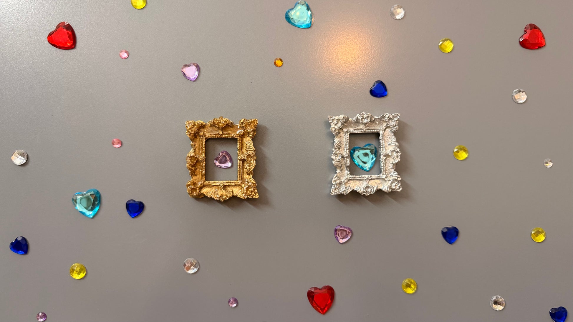 The Relic Magnetic Frame, gold and silver concrete miniature rococo frames side by side on a fridge door