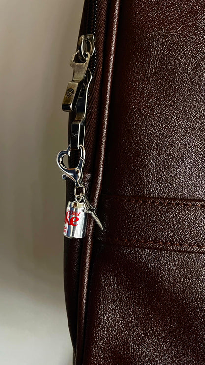 Metallic Diet Coke can bag charm with star pendant on a heart-shaped clasp, dark brown bag