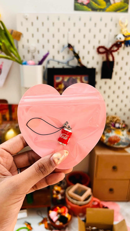 Red Coca-Cola mini can phone charm with black strap in a pink heart gift pouch