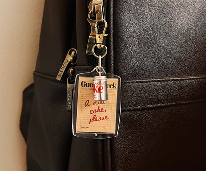 Acrylic guest check bag charm reading A diet coke, please with mini silver can on a black bag