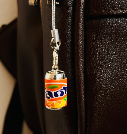 Orange Fanta mini can phone charm with silver strap on a dark brown bag