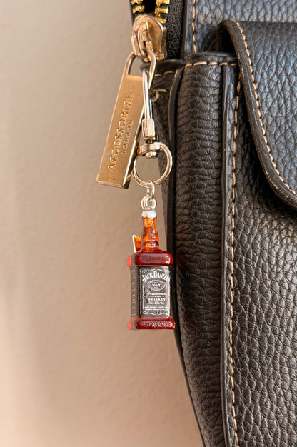 Jack daniels with Thunderbolt, a miniature whiskey bottle with a silver thunderbolt charm shown from another angle.