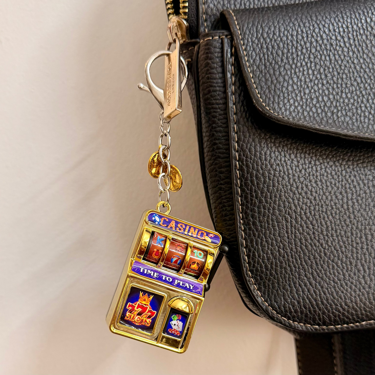 Jackpot, a gold casino slot machine charm with coin charms.