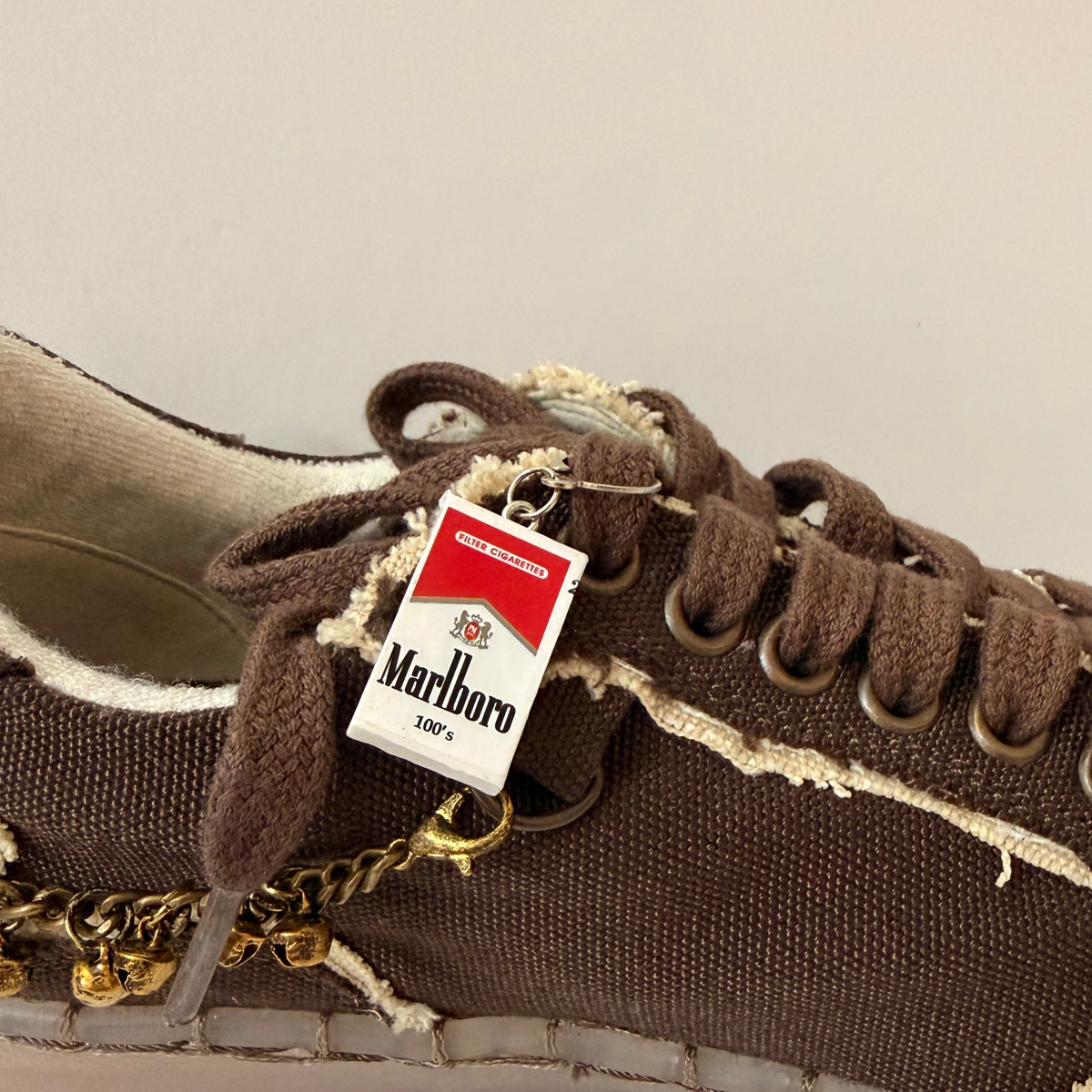 Marlboro Shoe Charm, mini Marlboro 100's pack charm on the laces of a brown canvas sneaker